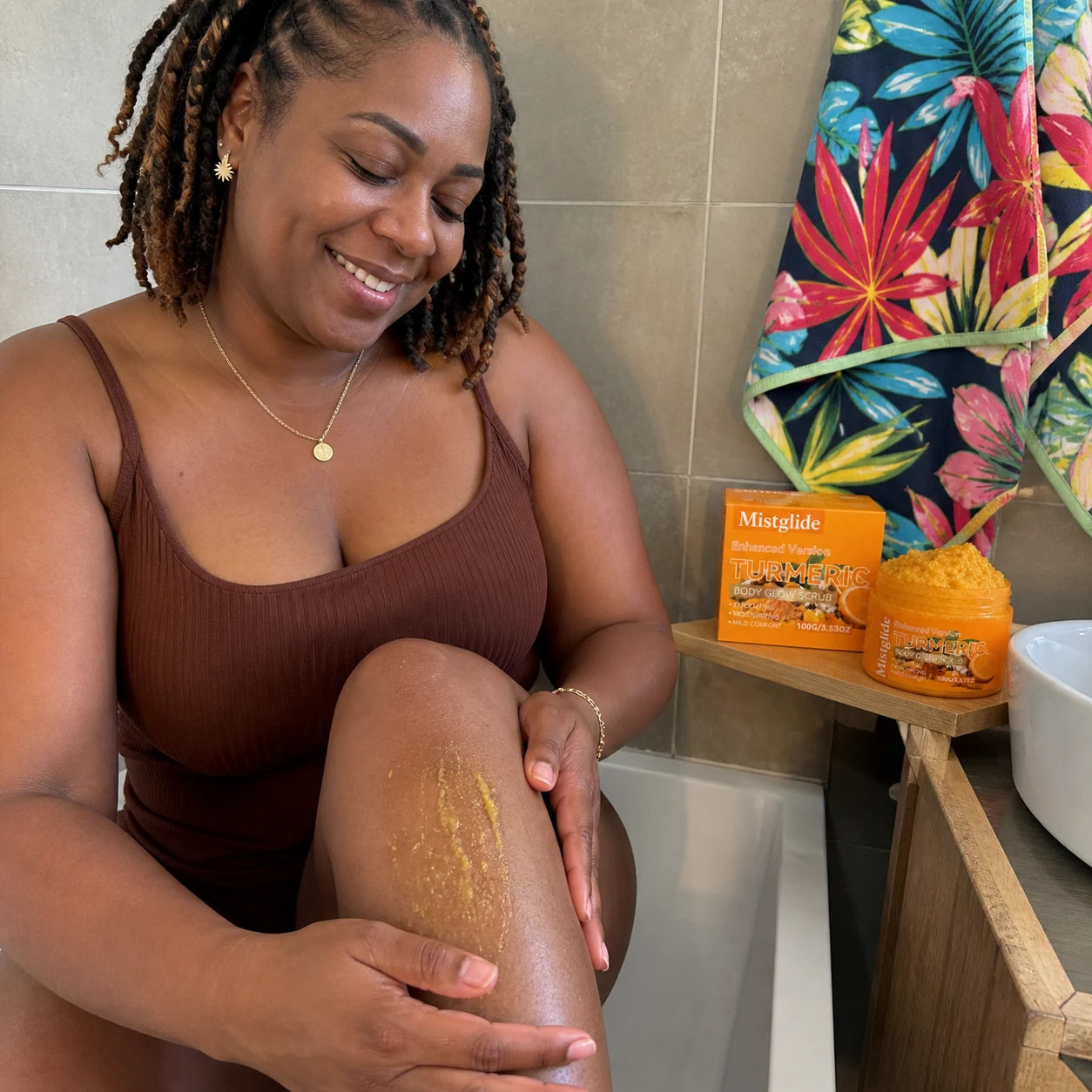 Cliente présentant le gommage corps Turmeric Mistglide dans une salle de bain lumineuse